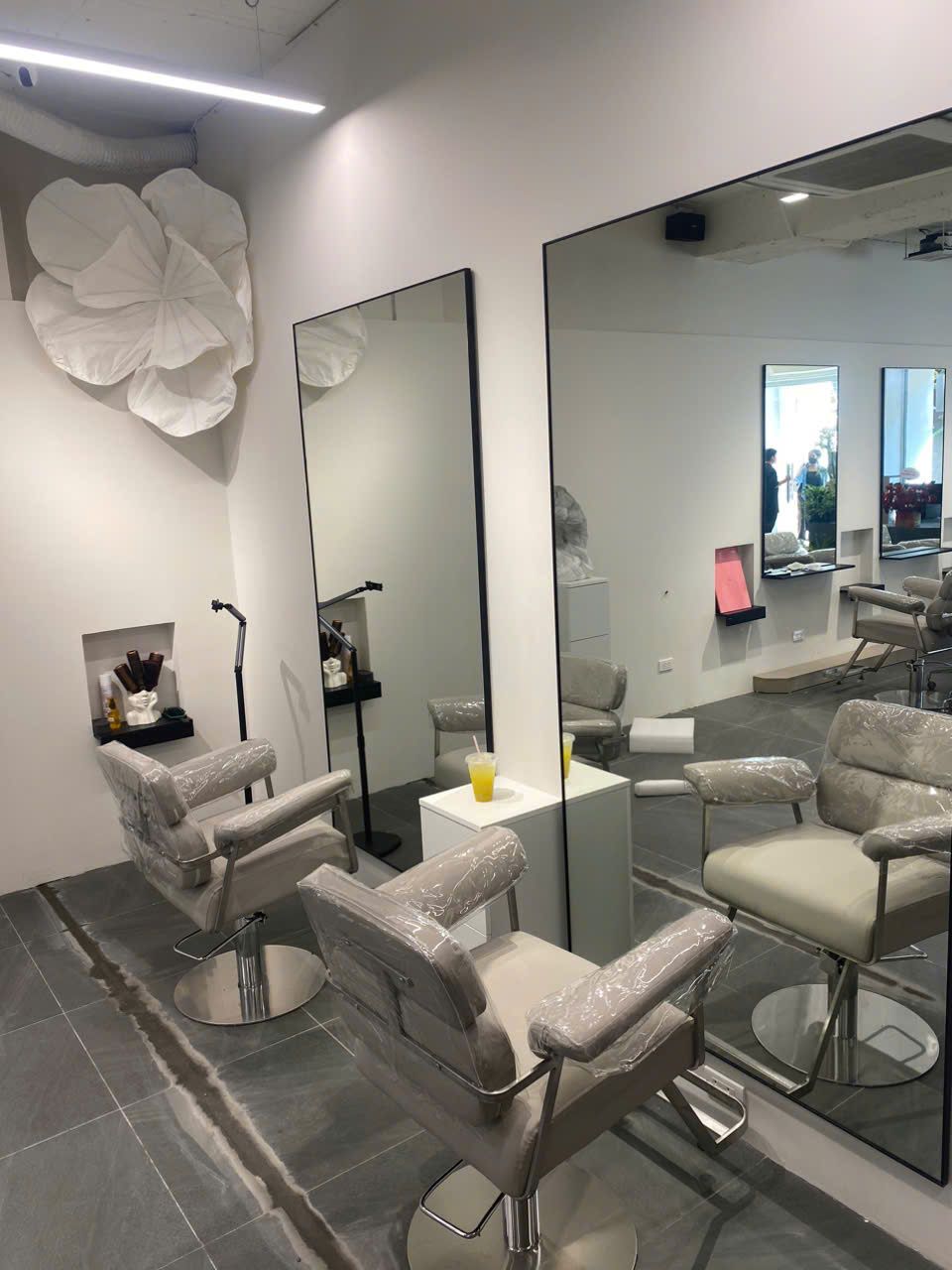 Ảnh thực tế ghế cắt và gương với mảng trang trí mây LUXA Hair Salon - Nội Thất Hà Tuấn LX